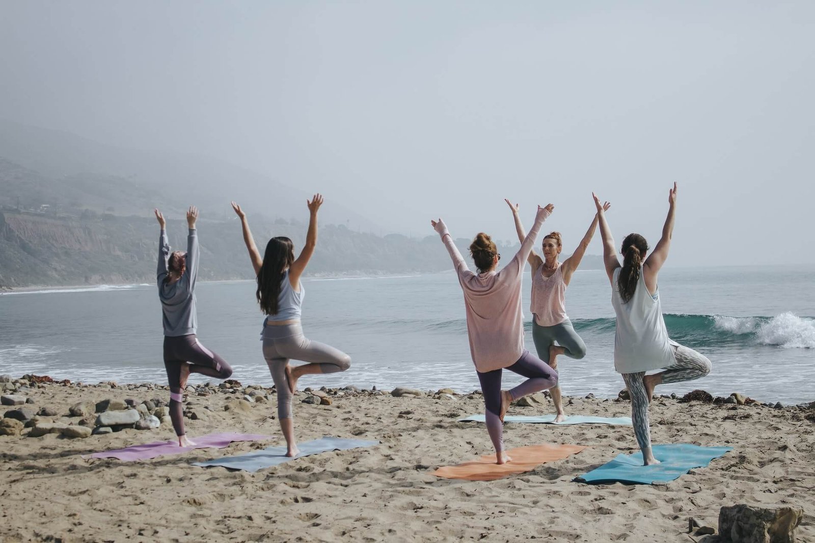 Mulheres praticando yoga na praia